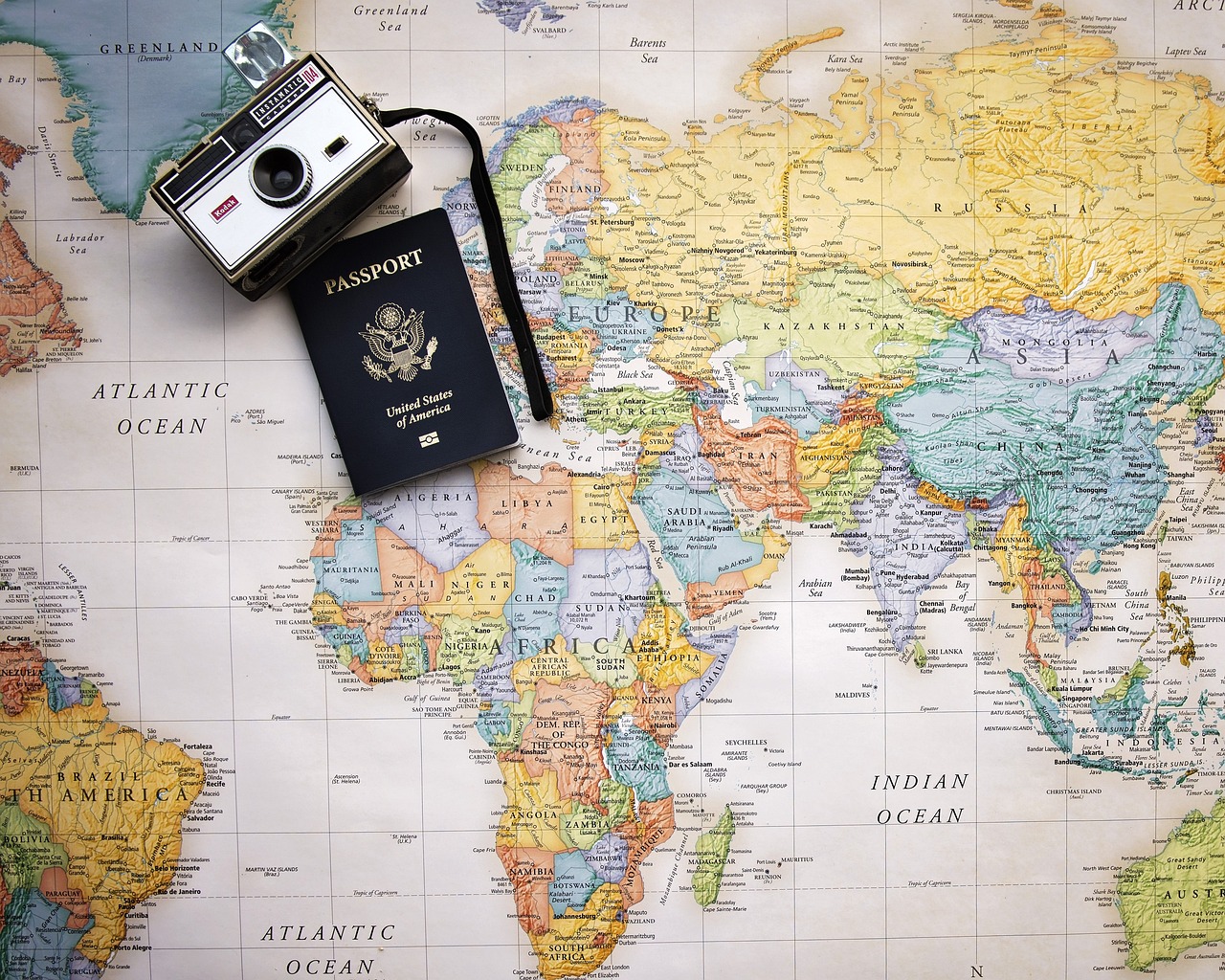 Cartina geografica con sopra un passaporto e una macchina fotografica